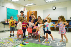 hands up, excited, education, teacher, student, classroom, camp, little kids, group photo, playful, fun